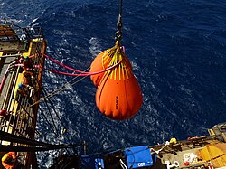 Floating crane vessel lifting heavy loads in a harbor, illustrating maritime heavy-lift and offshore construction capability.