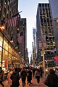 Skyscrapers line a busy sidewalk along 6th Avenue in New York City
