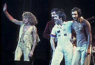 The Who on stage, standing and waving to a crowd